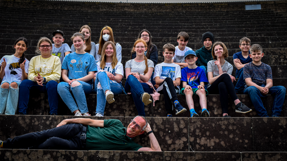 Schülergruppe auf Treppe mit Lehrer